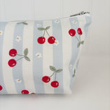 Nappy Wallet Cherry Stripe, close-up of the cherry and daisy print on the left side with the zip pull at the top right
