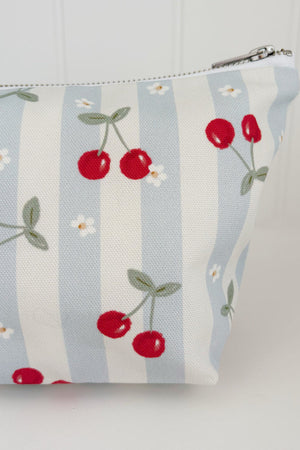 Nappy Wallet Cherry Stripe, close-up of the cherry and daisy print on the left side with the zip pull at the top right