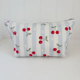 Nappy Wallet Cherry Stripe, front view of blue and cream striped zipped pouch with red cherries and small white flowers
