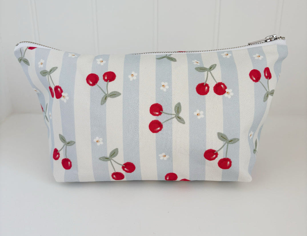 Nappy Wallet Cherry Stripe, front view of blue and cream striped zipped pouch with red cherries and small white flowers