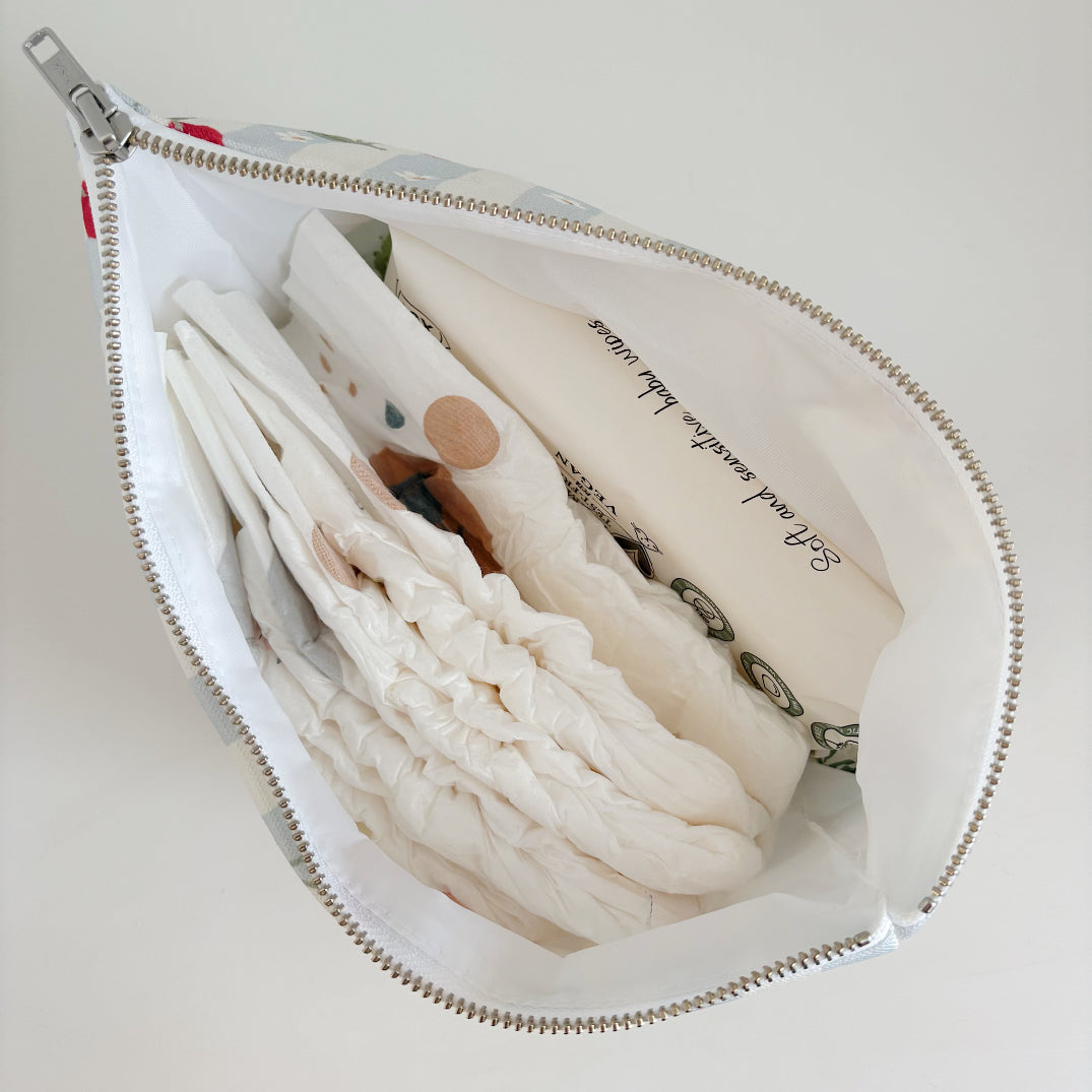 Nappy Wallet Cherry Stripe, open from above, holding several nappies and a pack of baby wipes with a white lining