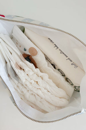 Nappy Wallet Cherry Stripe, open from above, holding several nappies and a pack of baby wipes with a white lining