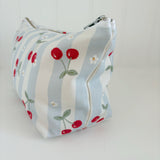 Nappy Wallet Cherry Stripe, side view showing the cherry print on the stripes and the zip end at the top