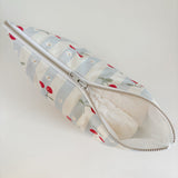 Nappy Wallet Cherry Stripe, partly unzipped with a nappy visible inside the white lining