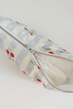 Nappy Wallet Cherry Stripe, partly unzipped with a nappy visible inside the white lining