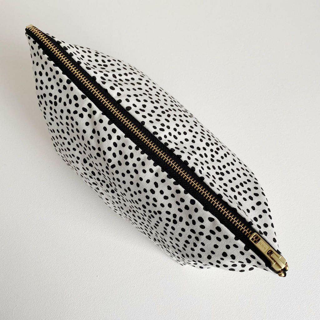 Nappy wallet in dalmatian print, seen from above with the gold zip closed along the top of the pouch