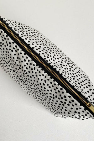 Nappy wallet in dalmatian print, seen from above with the gold zip closed along the top of the pouch