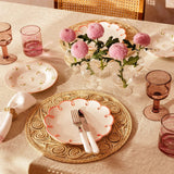 Pretty in Pink Scalloped Lunch Plate on a woven placemat with cutlery, on a table with pink flowers and glasses