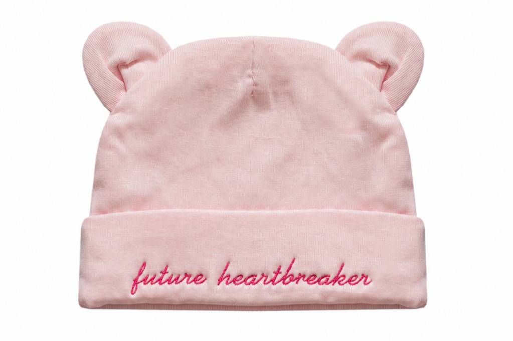 Pink beanie with bear ears and 'future heartbreaker' text on a white background
