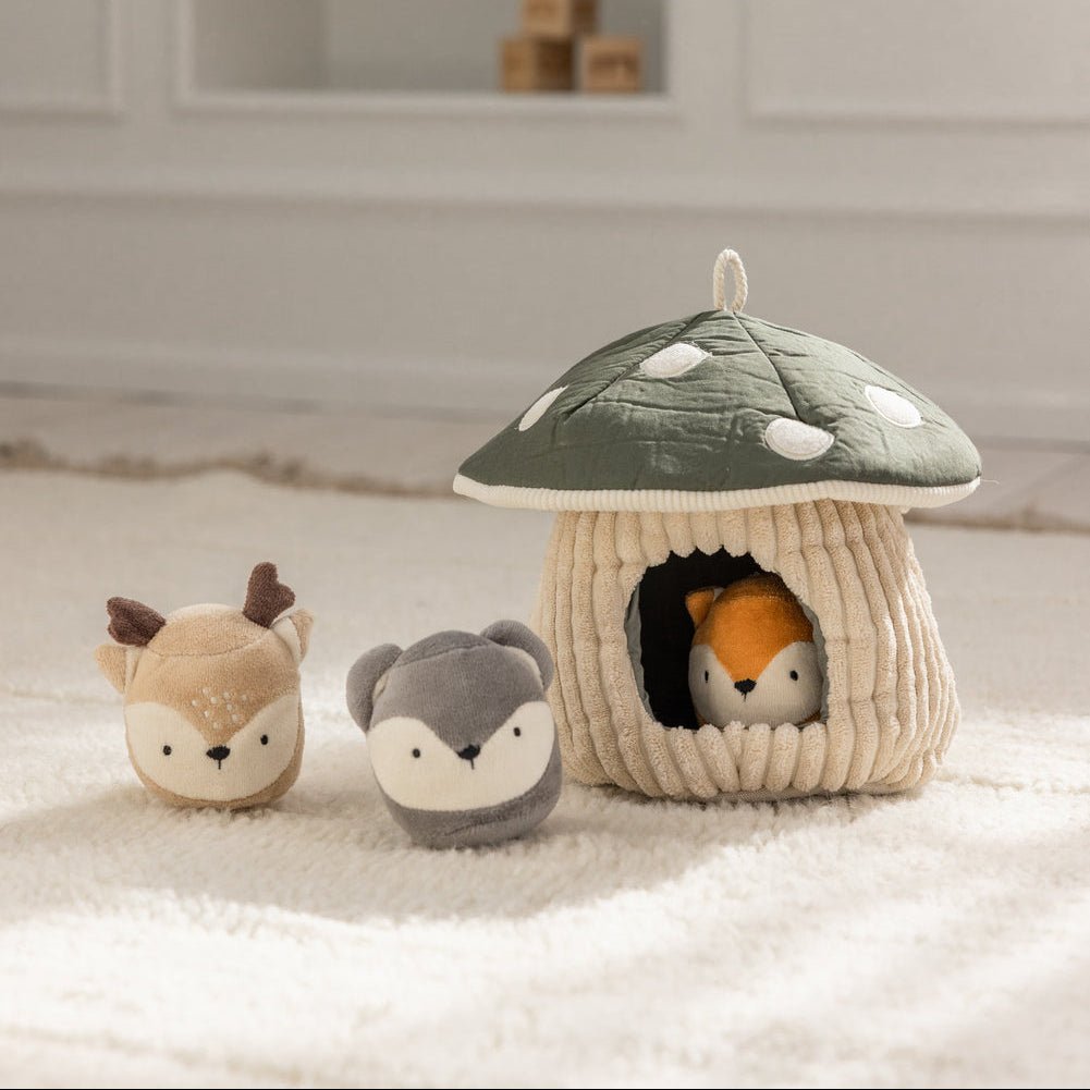 Hide & Seek Mushroom Activity Toy with a fox peeking from the doorway and a deer and mouse beside it on a fluffy rug