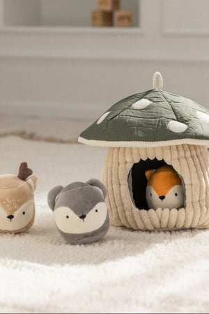 Hide & Seek Mushroom Activity Toy with a fox peeking from the doorway and a deer and mouse beside it on a fluffy rug