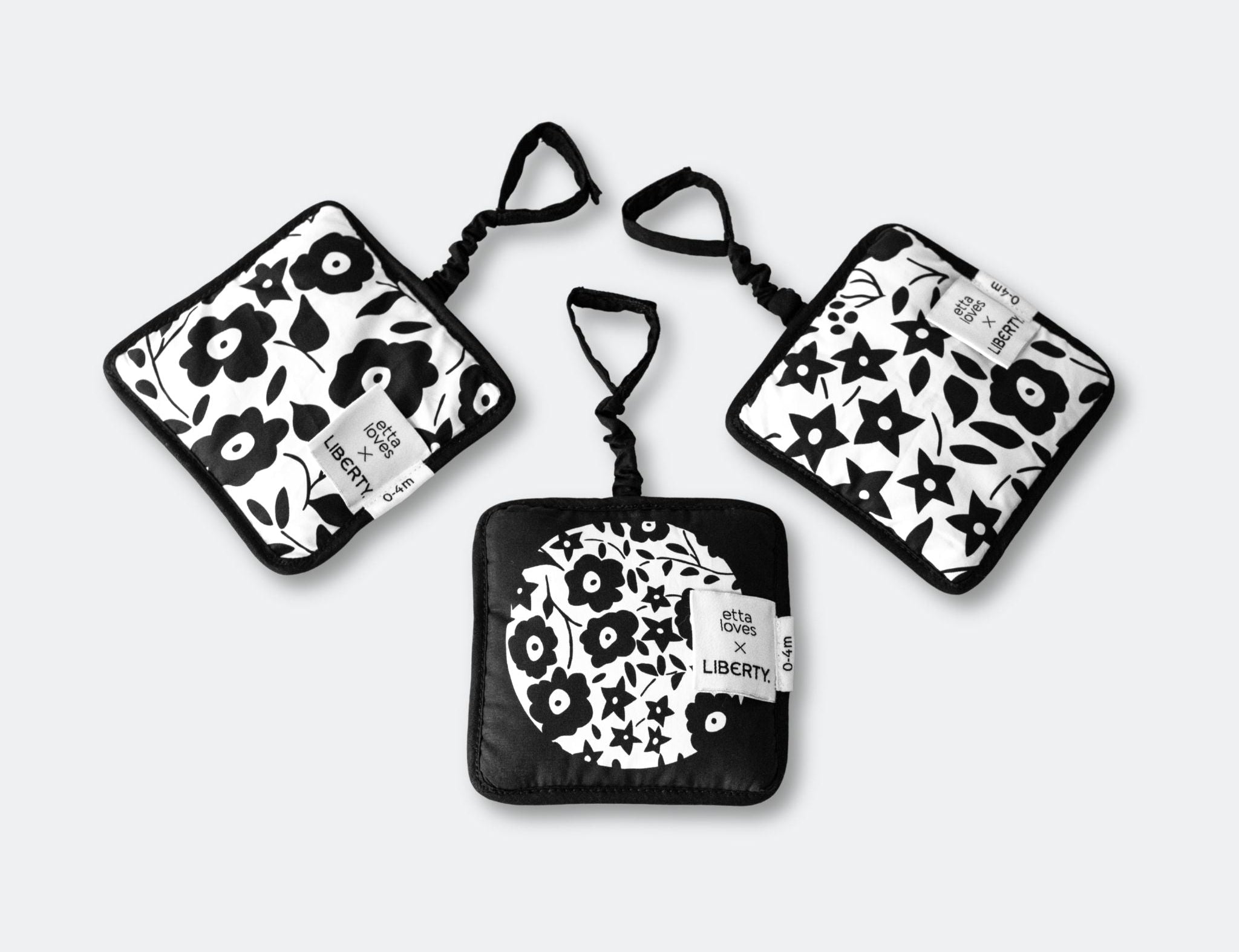 Set of three black and white patterned pouches on a light gray background