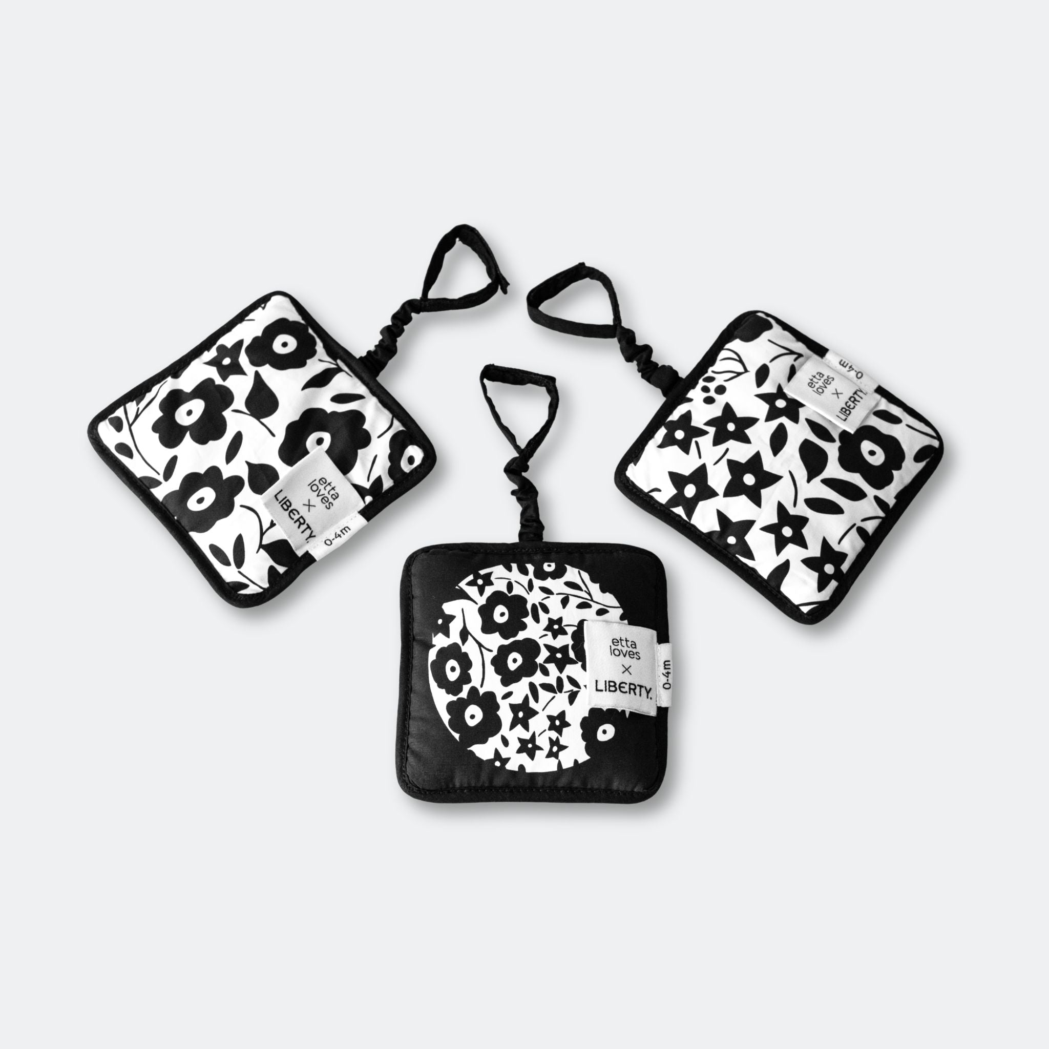 Set of three black and white patterned pouches on a light gray background