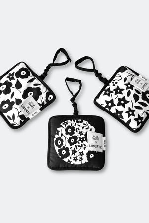 Set of three black and white patterned pouches on a light gray background