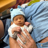 Newborn baby being held by an adult in a casual setting