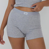 A close-up of a model wearing heather gray ribbed boxer briefs with a light gray elastic waistband and a visible RENSE brand label.