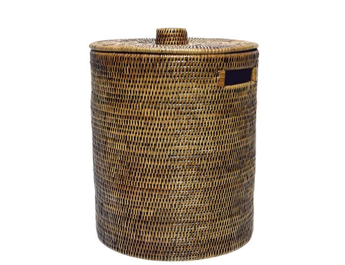 Handwoven Luxe Washing Hamper, a tall round woven basket with a lid and a cut-out side handle, on white