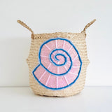 Shell belly basket, large, front view with a pink and blue woollen spiral shell design and two woven handles