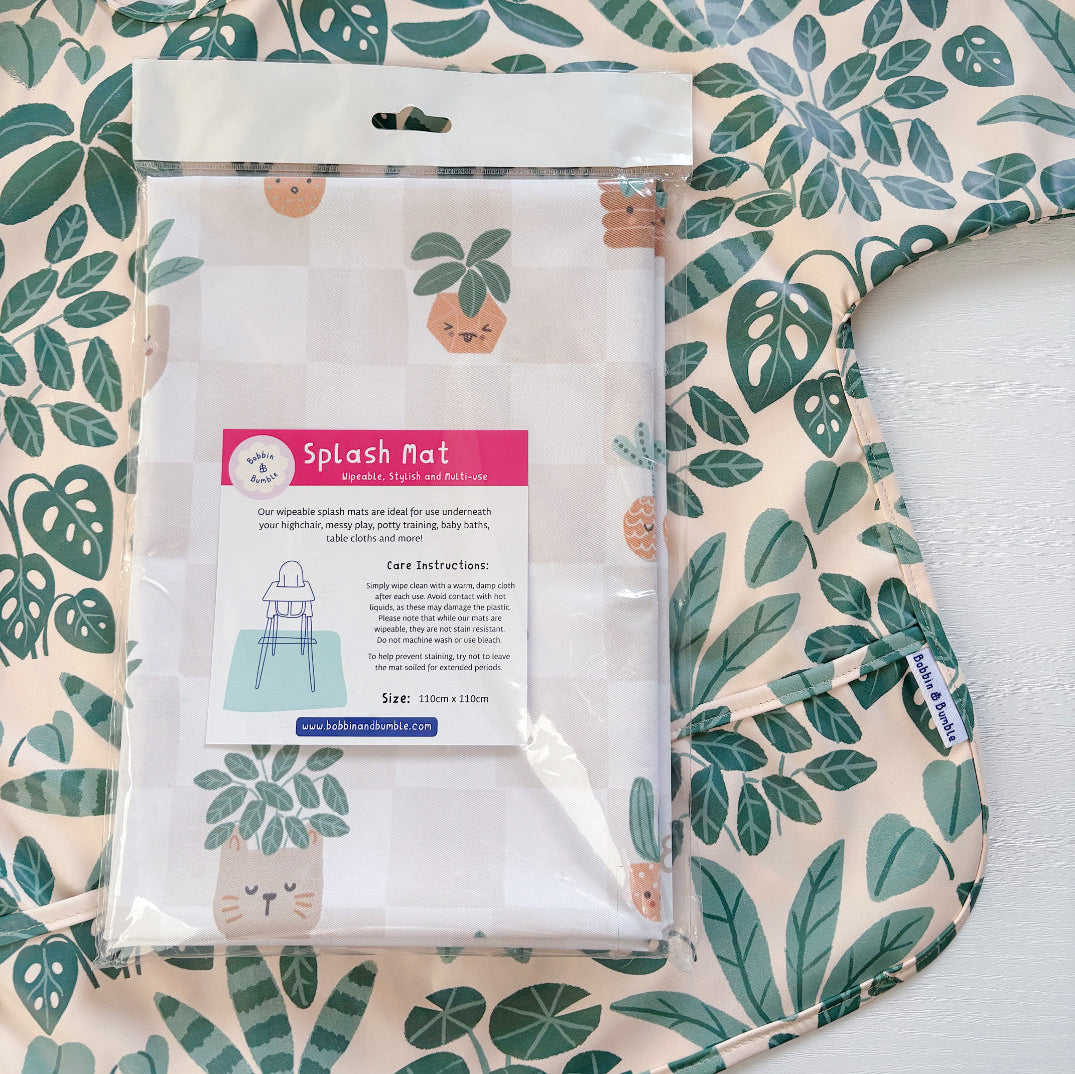 Splash Mat, Pot Plants: in its packaging laid on a matching leaf print long-sleeved bib