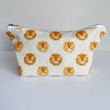 Nappy wallet in Leo lion print, front view of the zipped pouch with lion faces on a cream zigzag pattern