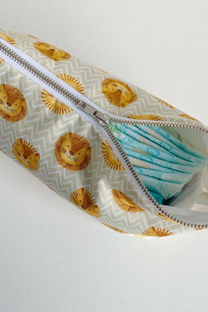 Nappy wallet in Leo lion print, partly unzipped at an angle with a stack of nappies showing through the opening