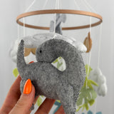 Little Dino Land felt cot mobile, hand holding the grey long-necked dinosaur from another angle, curved neck visible