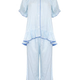 A light blue two-piece pajama set featuring a short-sleeve button-front top with ruffle details and matching wide-leg pants with ruffle hems, shown on a plain white background.