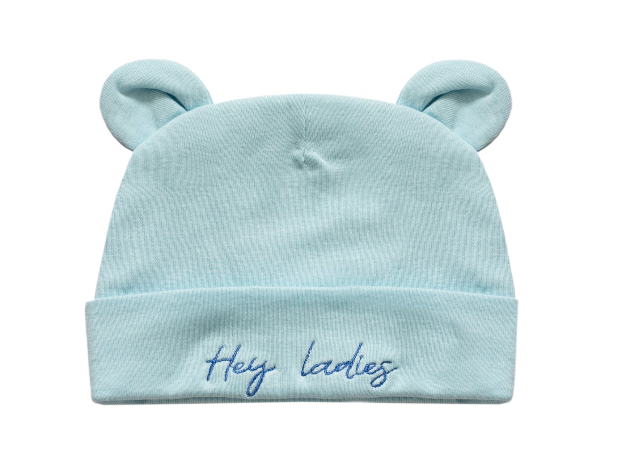 A light blue baby beanie hat with two small bear ears on top and the embroidered text 'Hey ladies' on the front cuff, shown against a plain white background.