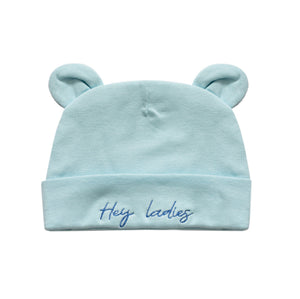 A light blue baby beanie hat with two small bear ears on top and the embroidered text 'Hey ladies' on the front cuff, shown against a plain white background.
