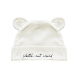 An off-white knit baby beanie hat featuring embroidered bear ears on top and the phrase 'Watch out world' in black script on the folded cuff.