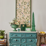 Mia Emerald Mosaic Photo Frame 6x4 on a teal chest of drawers with a green obelisk, urn of flowers and framed artwork