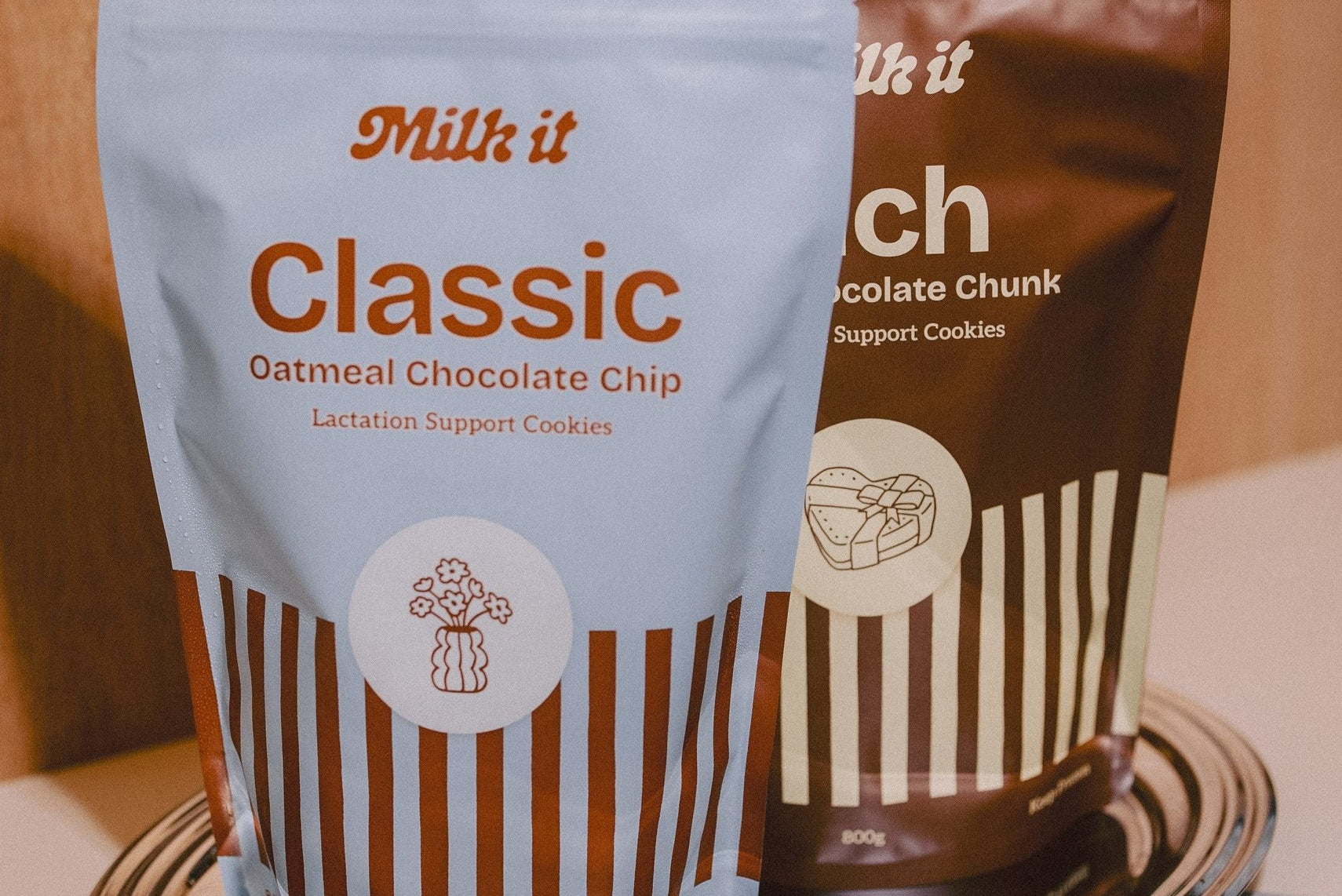 Milk it lactation cookie dough bundle: blue Classic and brown Rich pouches, 800g, standing together on a metal tray