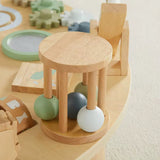 Wooden activity table, natural: close-up of the round wooden rattle drum with green, grey and white balls inside