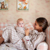 Beatrice Rose Stripe nightie worn by woman and baby in matching prints, smiling together on a pink checked sofa