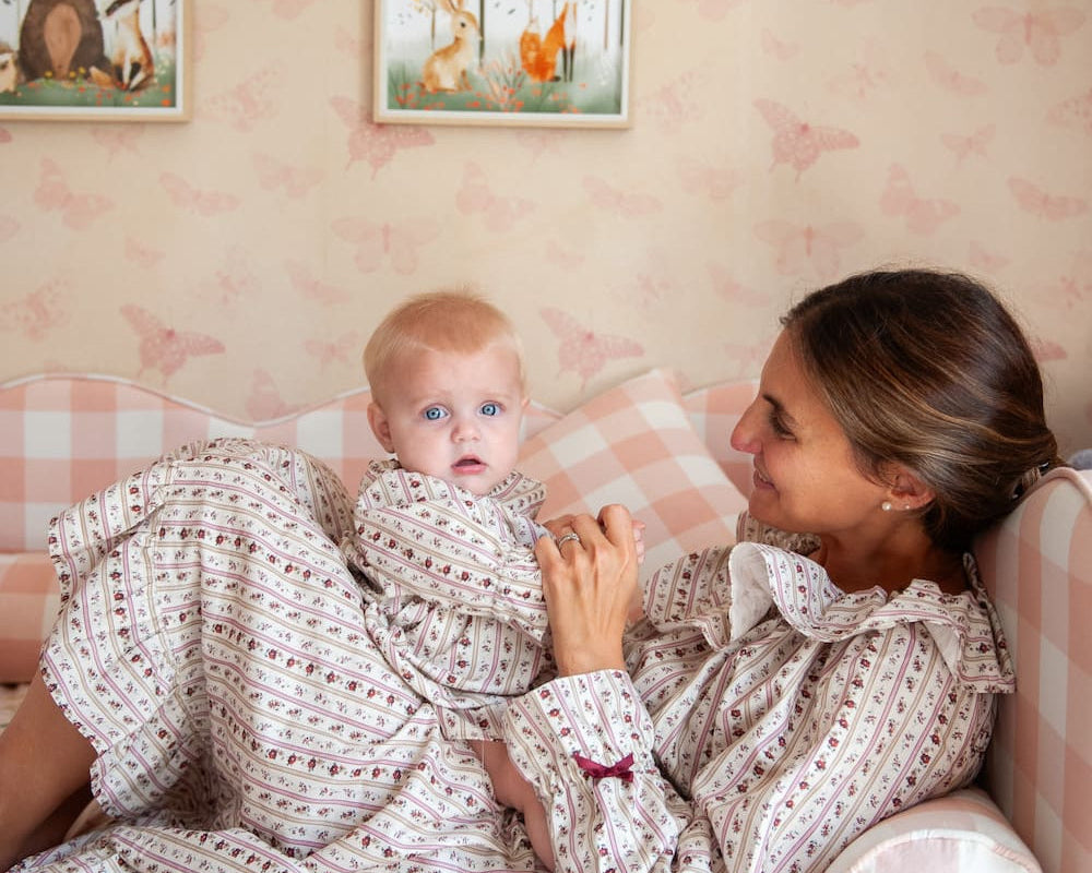 Beatrice Rose Stripe nightie worn by woman and baby in matching prints, smiling together on a pink checked sofa
