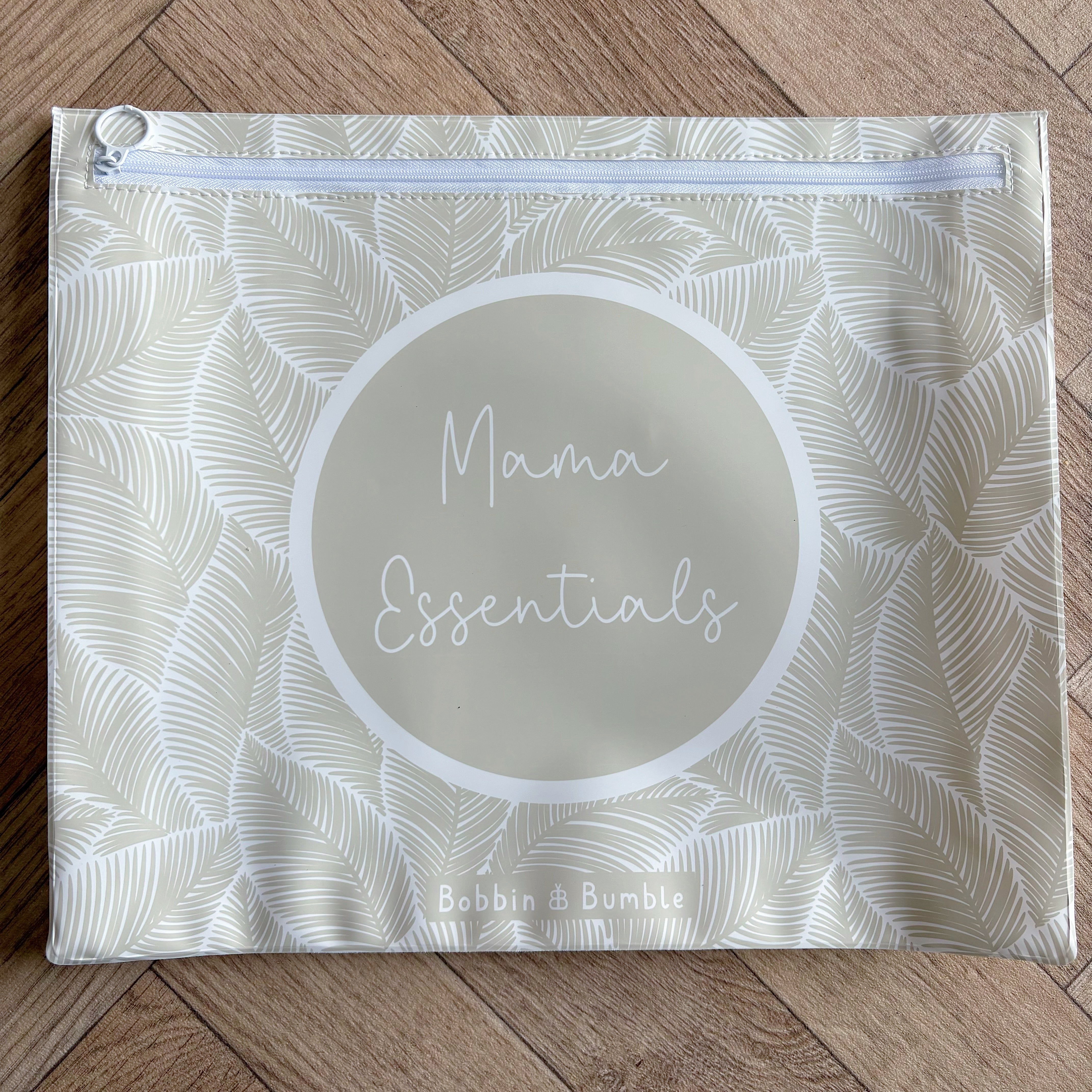 Hospital bag organiser pouches, beige leaf, flat pouch labelled Mama Essentials on a wooden floor