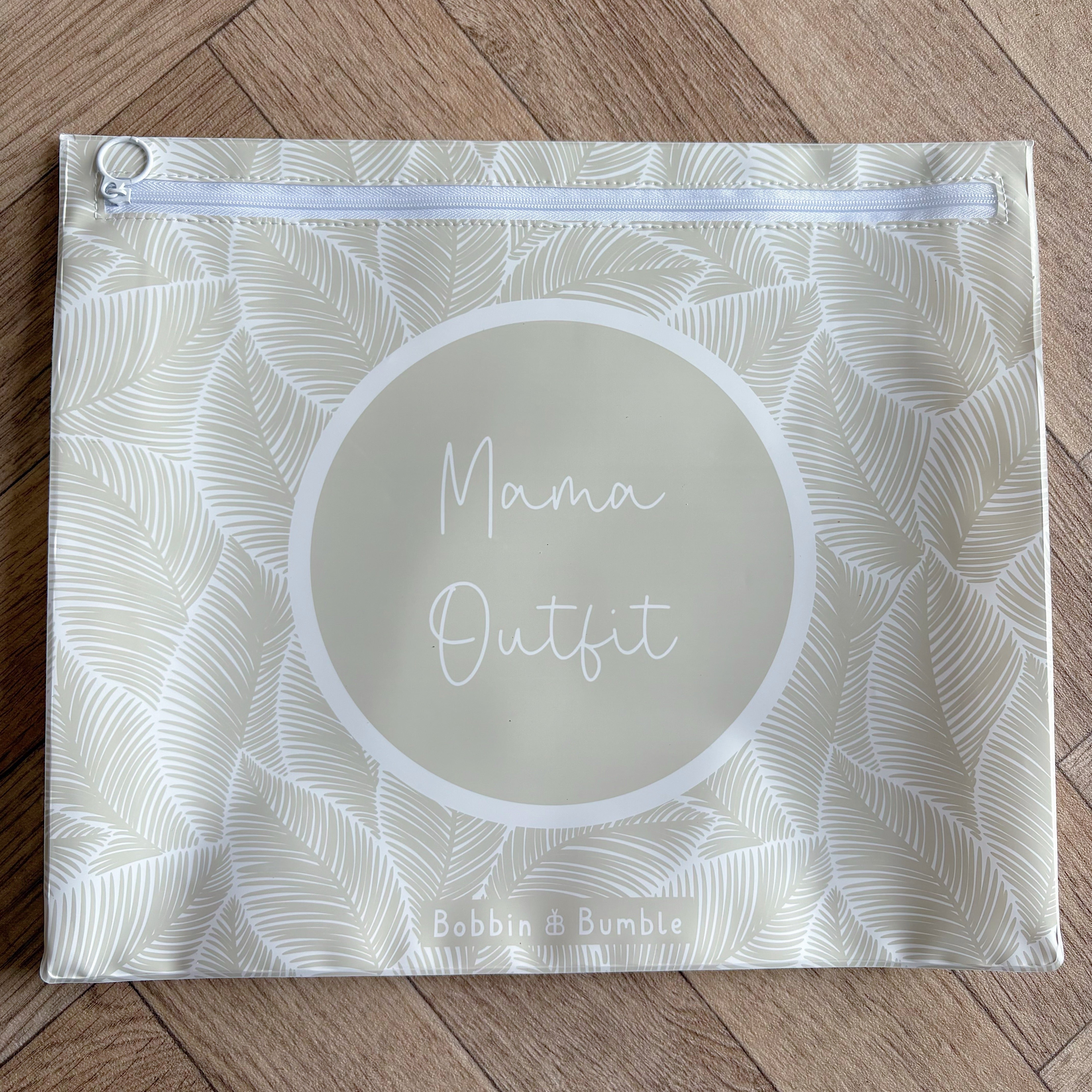 Hospital bag organiser pouches, beige leaf, flat pouch labelled Mama Outfit on a wooden floor