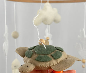 Ocean Whispers felt cot mobile detail of the felt turtle with green shell patches held in a hand
