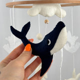 Ocean Whispers felt cot mobile detail of the navy and cream felt whale held in a hand