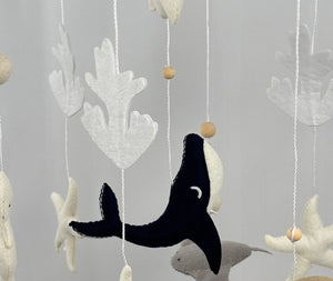 Ocean Whispers felt cot mobile close up of the navy whale, grey stingray, starfish, coral and turtle hanging below the ring