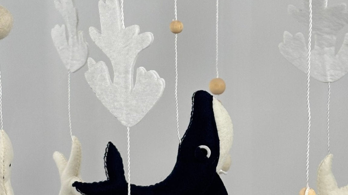 Ocean Whispers felt cot mobile close up of the navy whale, grey stingray, starfish, coral and turtle hanging below the ring