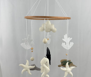 Ocean Whispers felt cot mobile hanging full length from a wooden hook, seahorse, turtle, starfish and cloud at the front
