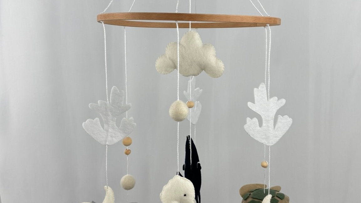 Ocean Whispers felt cot mobile hanging full length from a wooden hook, seahorse, turtle, starfish and cloud at the front