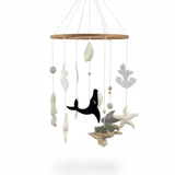 Ocean Whispers felt cot mobile on a white background, wooden ring with whale, turtle, stingray, starfish and coral