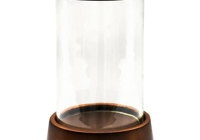 Palm Beach Hurricane Lantern with a clear glass cylinder and a copper-toned base and rim, on white