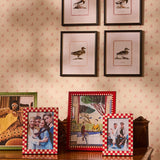 Classic Red Checked Photo Frame 7x5 displayed with other frames on a carved wooden table below framed duck prints