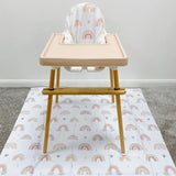 Splash Mat Beau Pink Rainbow Print laid on carpet under a wooden high chair with a pink tray and matching seat cushion