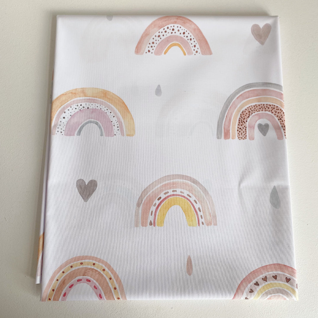 Splash Mat Beau Pink Rainbow Print, folded flat showing a pattern of pink and yellow rainbows, hearts and raindrops