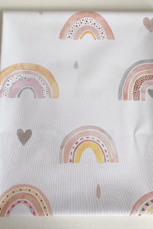 Splash Mat Beau Pink Rainbow Print, folded flat showing a pattern of pink and yellow rainbows, hearts and raindrops