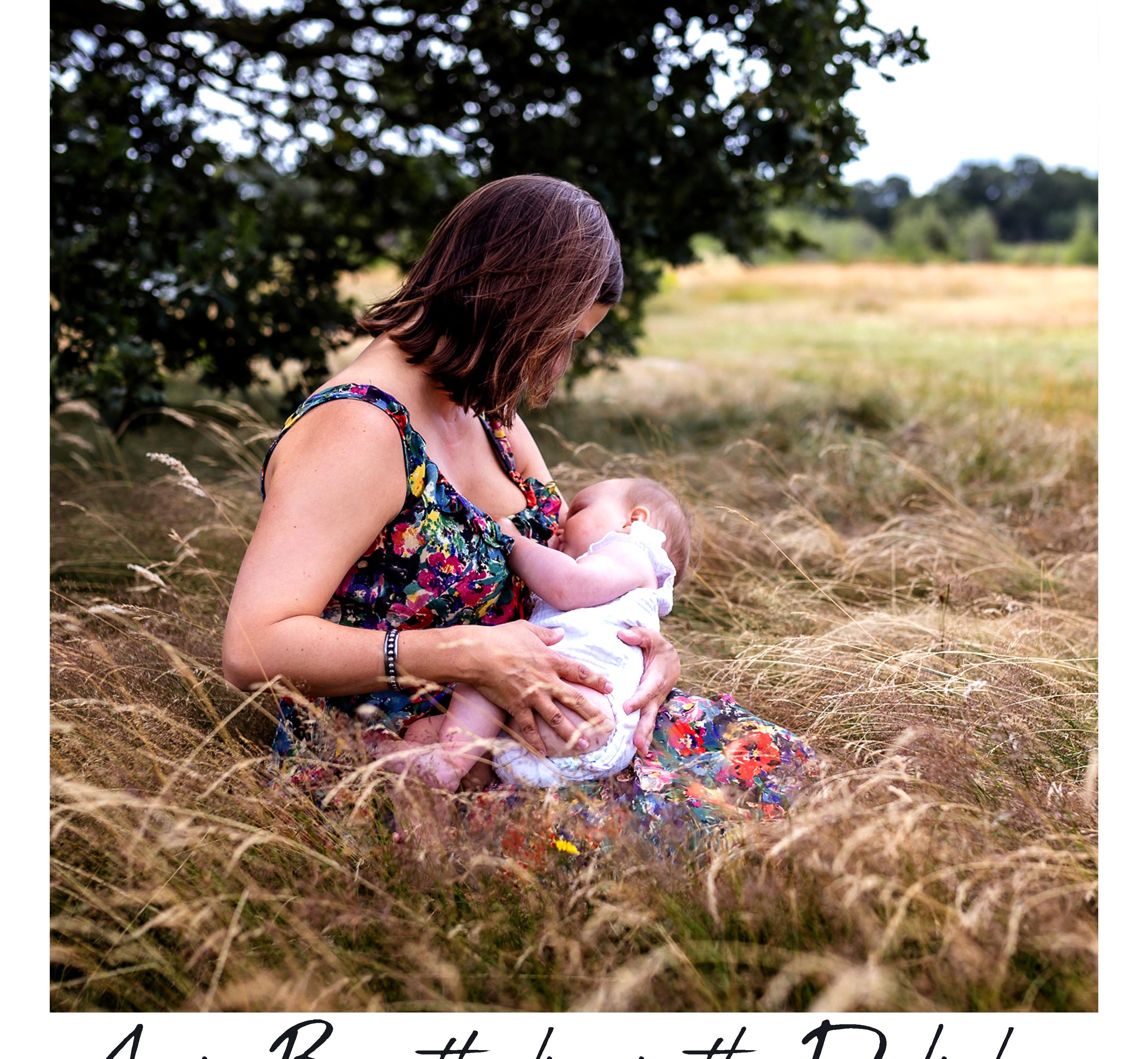 A woman in a colorful floral maternity dress breastfeeding a baby in a grassy outdoor field under a tree. The text 'Annie Breastfeeding in the Dali dress' is written at the bottom.
